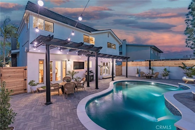 pool at dusk featuring french doors, a pergola, and a patio area