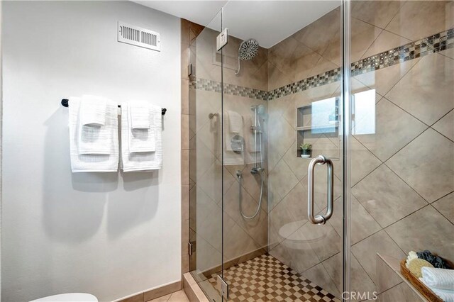 bathroom with toilet and a shower with shower door