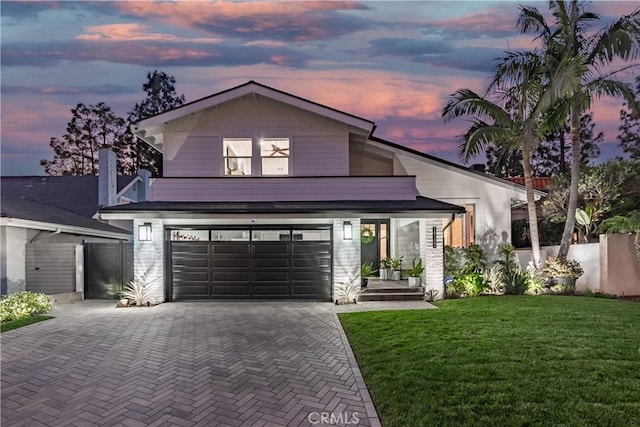 view of front of house with a garage and a yard