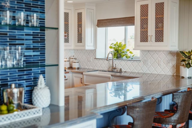 kitchen featuring white cabinetry, sink, and backsplash