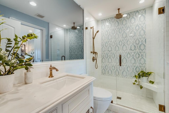 bathroom featuring vanity, toilet, and a shower with door