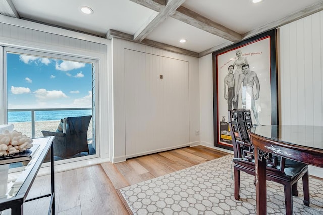 dining room with beamed ceiling, a water view, coffered ceiling, and light wood-type flooring