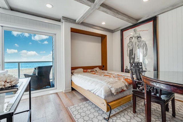 bedroom with beamed ceiling, a water view, coffered ceiling, and light hardwood / wood-style floors