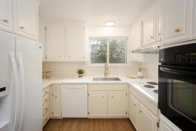 kitchen featuring sink, light wood-type flooring, white cabinets, white appliances, and backsplash