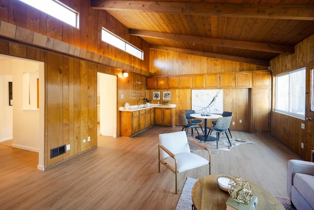 interior space featuring wood walls, lofted ceiling with beams, sink, wood ceiling, and light hardwood / wood-style floors