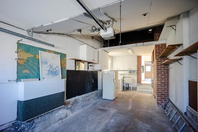 garage with sink, a garage door opener, and white fridge