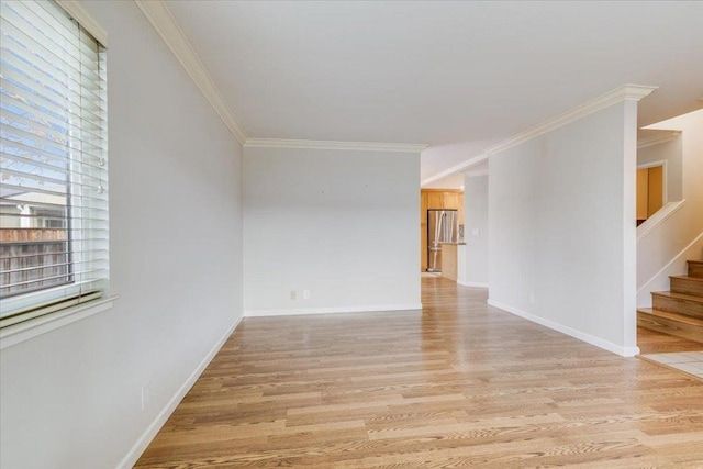 spare room with crown molding and light hardwood / wood-style flooring