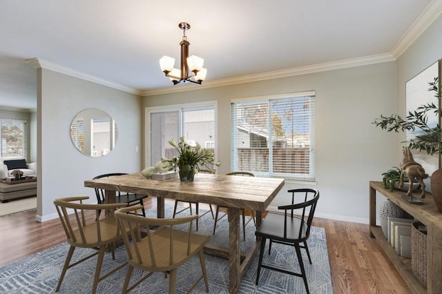 dining space featuring crown molding, wood-type flooring, and a chandelier