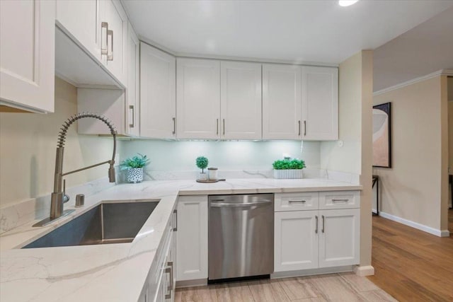 kitchen with sink, white cabinets, stainless steel dishwasher, light stone counters, and light hardwood / wood-style flooring