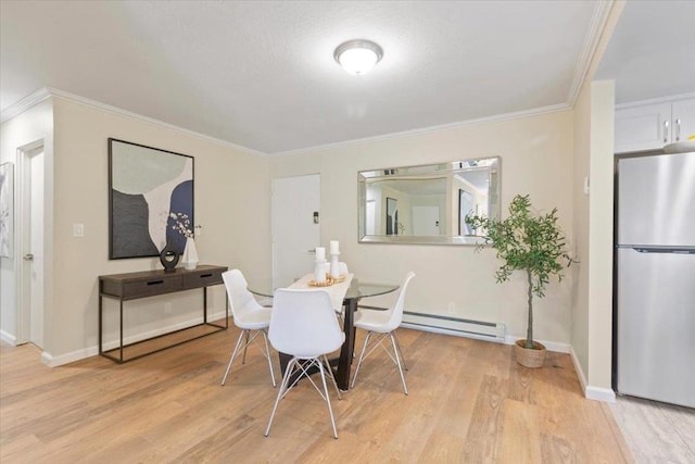 dining area with ornamental molding, light wood-type flooring, and a baseboard heating unit