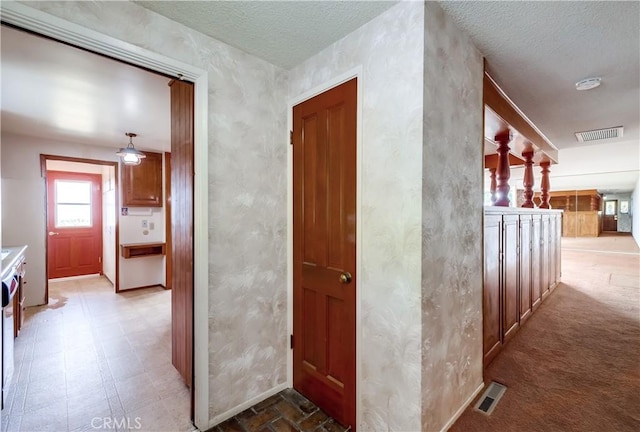 hall with a textured ceiling