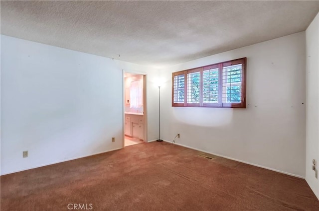 carpeted spare room with a textured ceiling