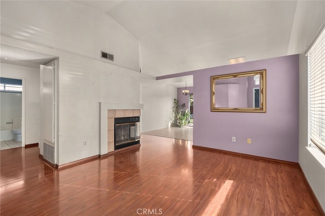 unfurnished living room with hardwood / wood-style floors, a fireplace, and high vaulted ceiling