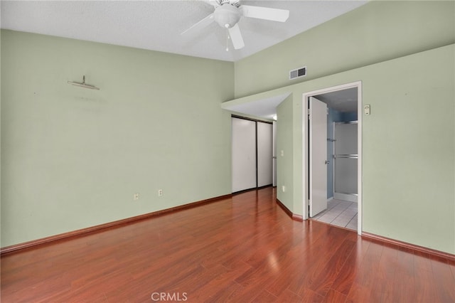 unfurnished bedroom with ceiling fan, connected bathroom, and light wood-type flooring