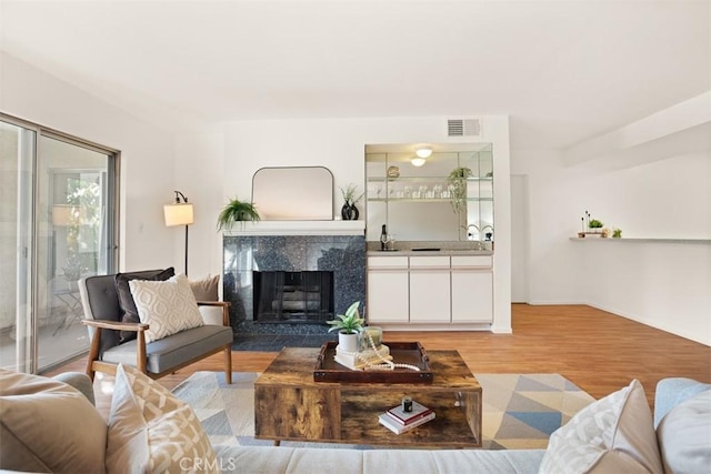 living room featuring a premium fireplace and light hardwood / wood-style floors