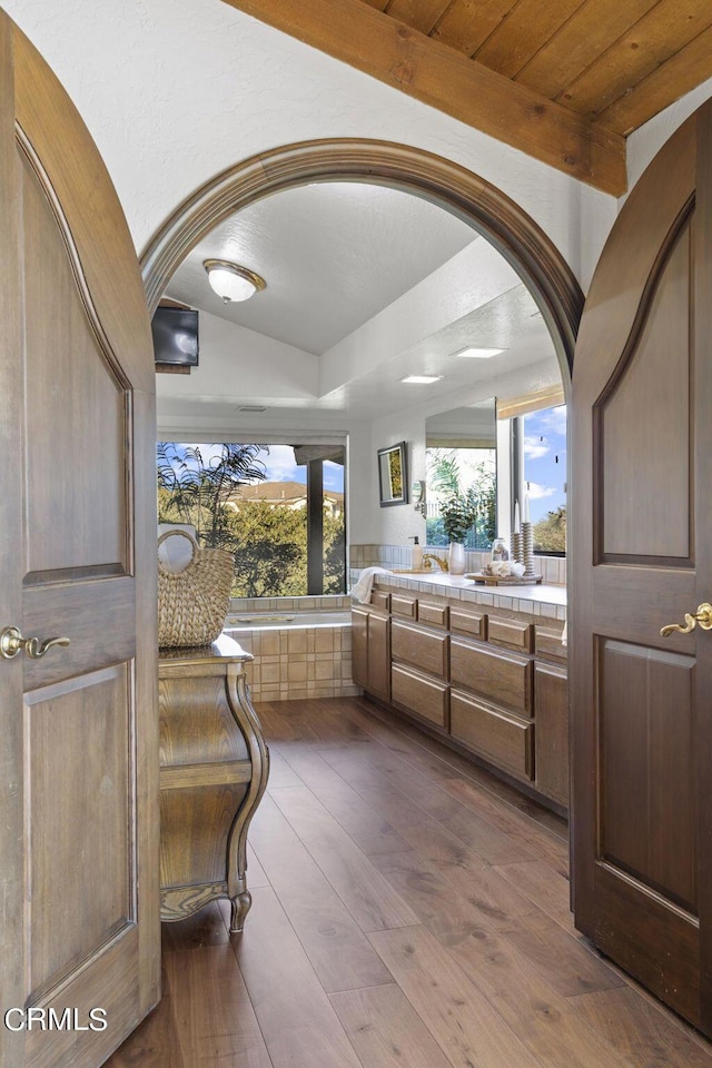 bathroom featuring hardwood / wood-style floors, vanity, and a washtub