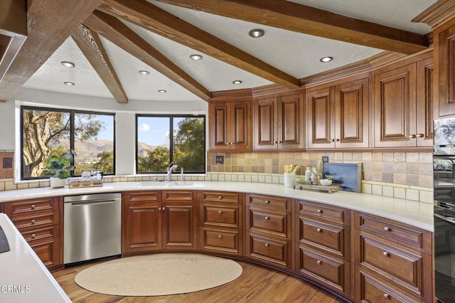 kitchen featuring sink, backsplash, beam ceiling, light hardwood / wood-style floors, and stainless steel dishwasher