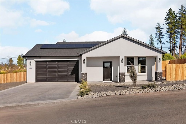 view of front of property featuring a garage and solar panels