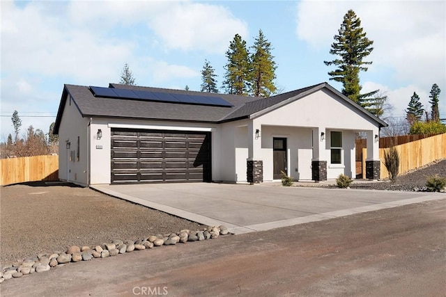 view of front of property featuring a garage and solar panels