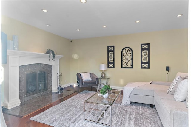 living room featuring recessed lighting, baseboards, wood finished floors, and a high end fireplace