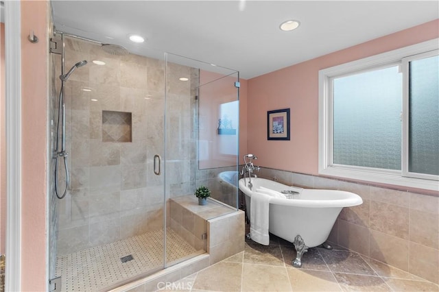 bathroom featuring recessed lighting, a shower stall, a freestanding bath, and tile walls