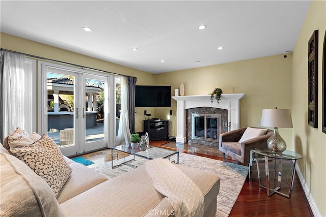 living room featuring recessed lighting, french doors, wood finished floors, and a fireplace