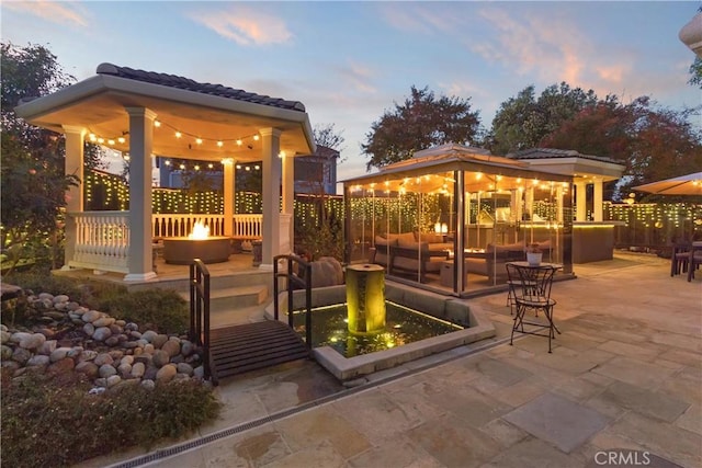 view of patio / terrace featuring a gazebo, an outdoor fire pit, and fence