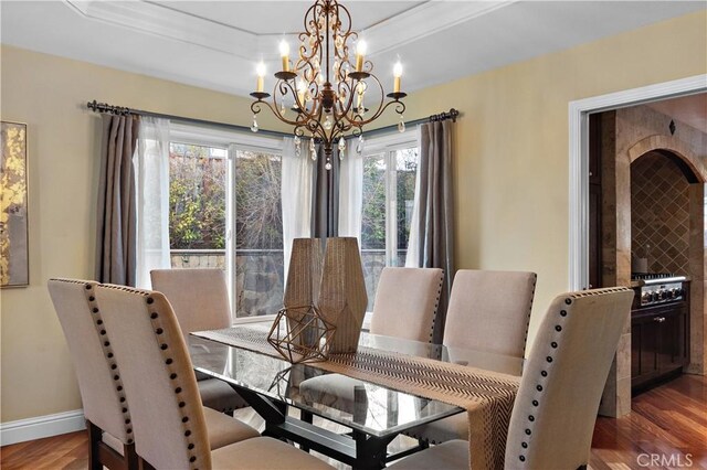 dining space featuring a notable chandelier, baseboards, and wood finished floors