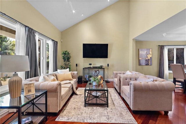 living room featuring high vaulted ceiling and dark wood-style flooring