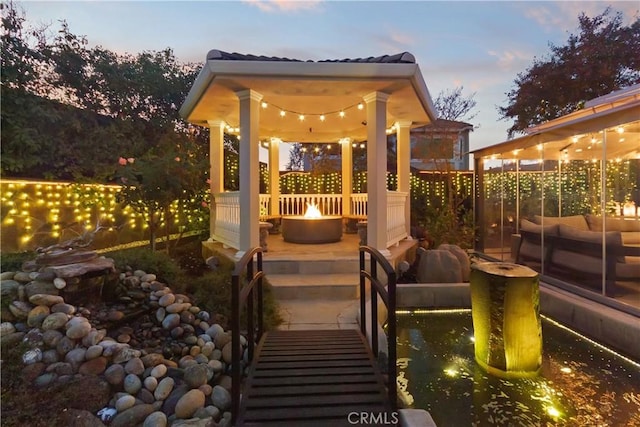 patio terrace at dusk with a fire pit and fence