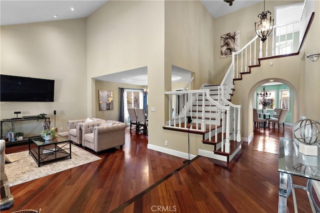 living area with stairway, an inviting chandelier, and a healthy amount of sunlight