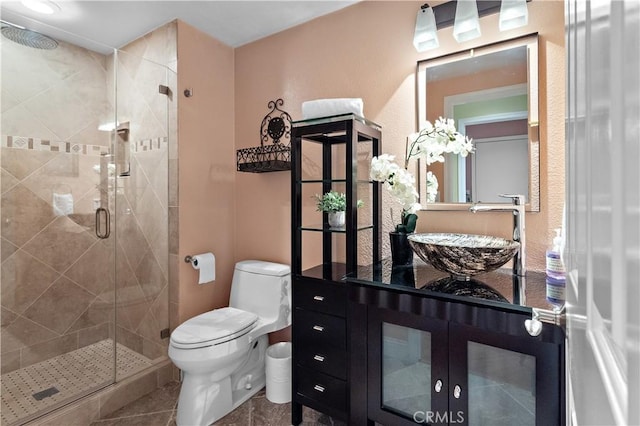 bathroom with a shower stall, toilet, and vanity