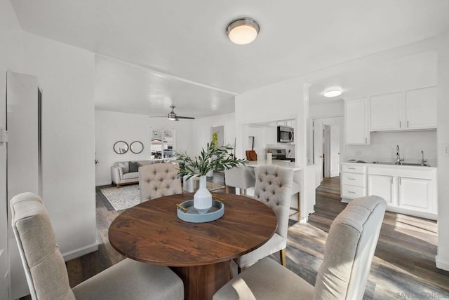 dining room with sink, dark hardwood / wood-style floors, and ceiling fan