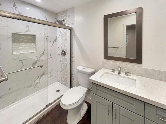 bathroom featuring vanity, toilet, and an enclosed shower