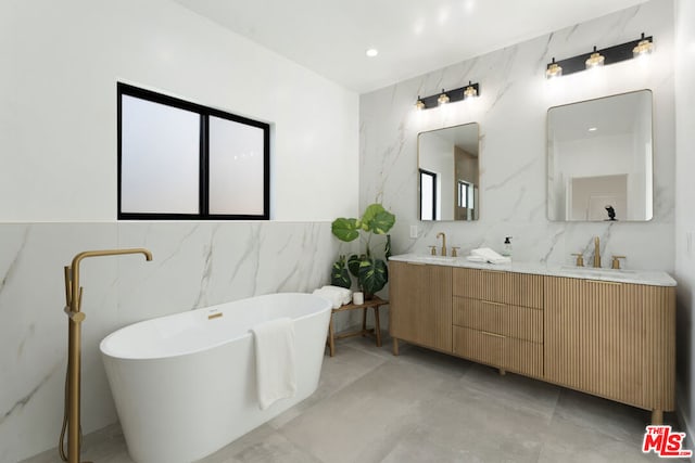 bathroom featuring vanity, tile walls, and a tub