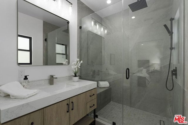 bathroom with vanity and a shower with shower door