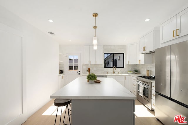 kitchen with sink, a center island, white cabinets, and appliances with stainless steel finishes