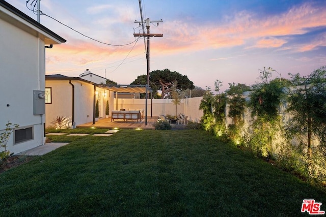 yard at dusk featuring a patio