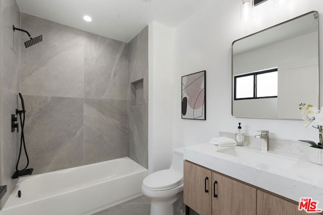 full bathroom with tiled shower / bath, vanity, and toilet