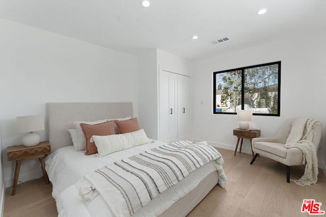 bedroom featuring light wood-type flooring and a closet