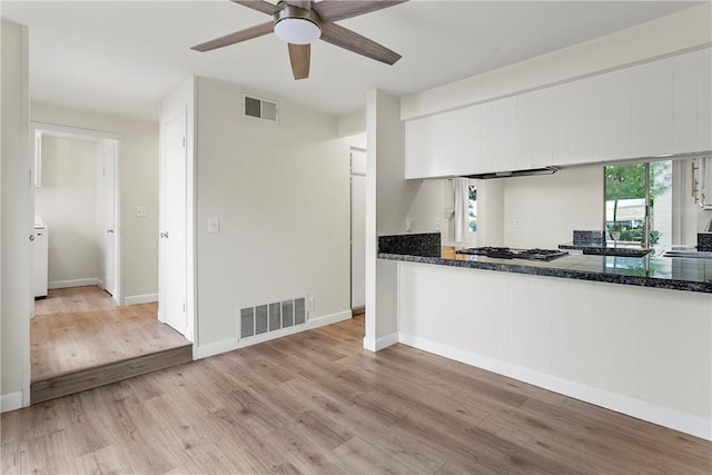 kitchen with ceiling fan, gas cooktop, white cabinets, and light wood-type flooring