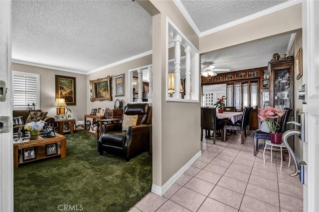 tiled living room featuring crown molding, a textured ceiling, ceiling fan, and ornate columns