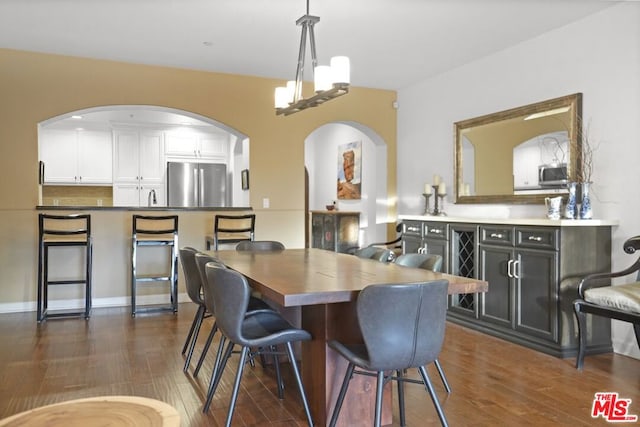 dining area with a notable chandelier and dark hardwood / wood-style floors