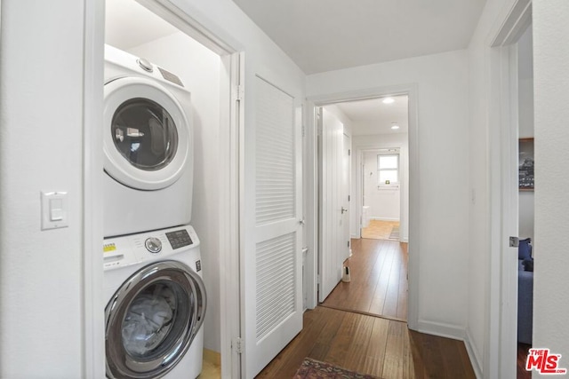 washroom featuring dark hardwood / wood-style flooring and stacked washer and dryer