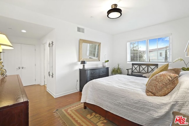 bedroom featuring hardwood / wood-style floors and a closet