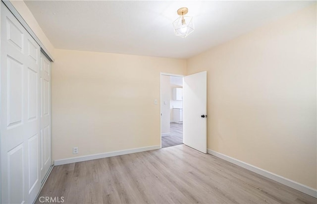 unfurnished bedroom featuring a closet and light wood-type flooring