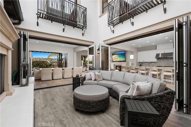 living room featuring a towering ceiling and light hardwood / wood-style flooring