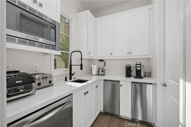 kitchen with appliances with stainless steel finishes, sink, and white cabinets