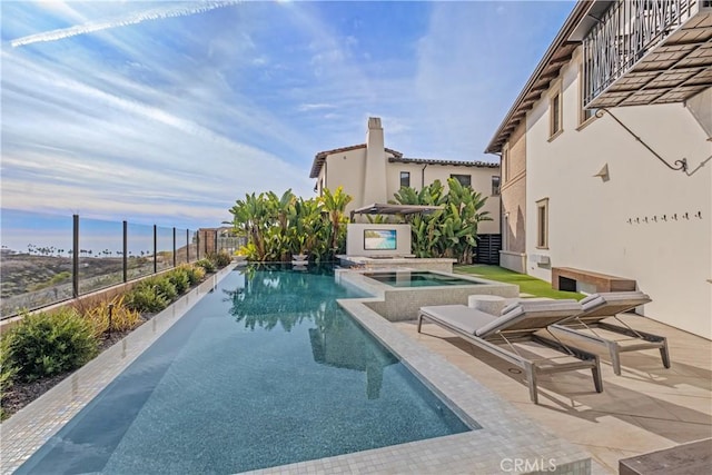 view of swimming pool featuring an in ground hot tub and a patio