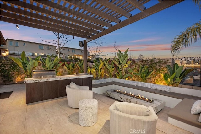 patio terrace at dusk featuring area for grilling, a pergola, and an outdoor living space with a fire pit